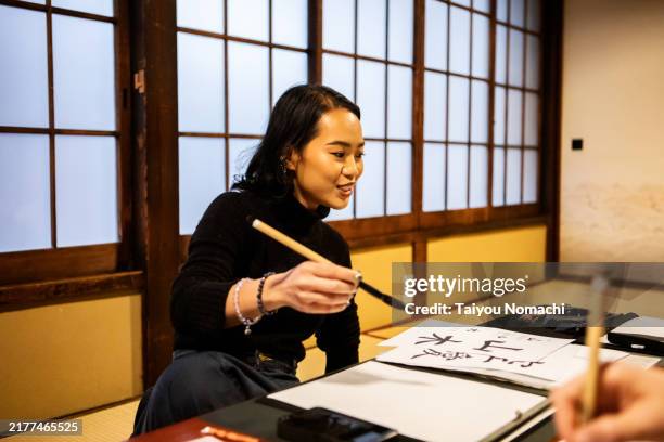 tourists from overseas who come to japan to experience calligraphy. - turismo esperienziale foto e immagini stock