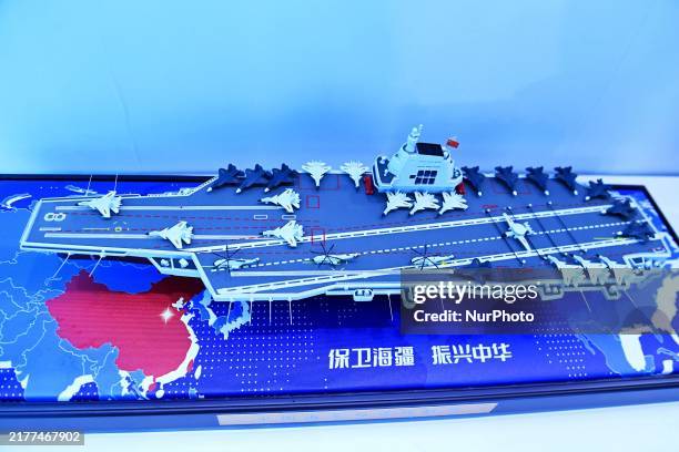 An exhibitor shows a model of the aircraft carrier Fujian at the 9th China Advanced Materials Industry Expo 2024 in Qingdao, China, on October 12,...