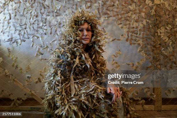 Olya, a member of the Gang of Angels, a volunteer group that makes camouflage netting for the Armed Forces of Ukraine, poses with a sniper camouflage...