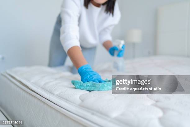 donna che spruzza il panno del materasso con detergenti speciali per rimuovere le macchie - acaro foto e immagini stock
