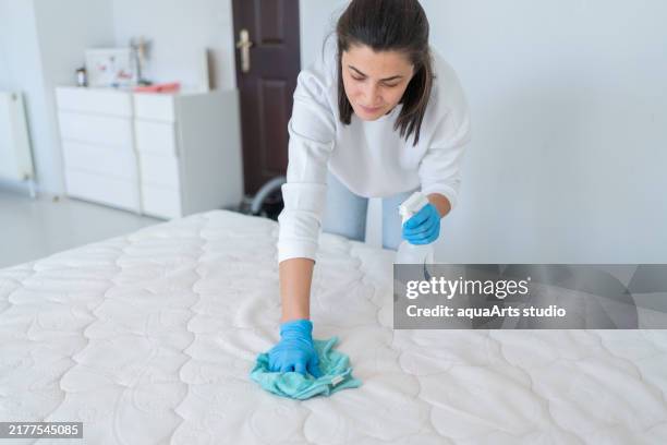 donna che spruzza il panno del materasso con detergenti speciali per rimuovere le macchie - acaro foto e immagini stock