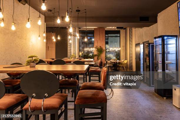 cozy modern cafe interior with ambient lighting and empty seating - light fitting stock pictures, royalty-free photos & images