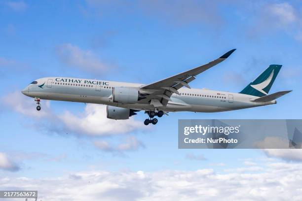 Cathay Pacific Airbus A350-900 passenger aircraft spotted flying over the houses in Myrtle Avenue before landing at London Heathrow Airport LHR. The...