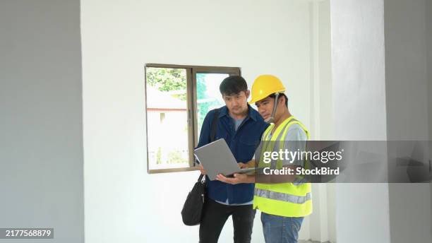 asiatischer ingenieur, der einem asiatischen mann, der am kauf eines hauses interessiert ist, struktur und stärke erklärt. hausprojektkonzept für festigkeit und statische standards. - schrumpfen stock-fotos und bilder