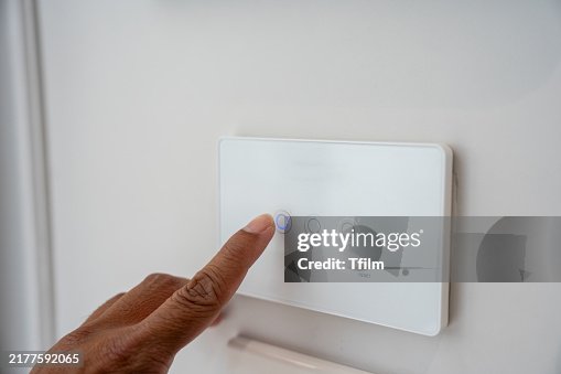 Person using smart home light switch panel Person using smart home light switch panel