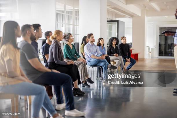 business professionals attending educational seminar at startup office - involvement stockfoto's en -beelden