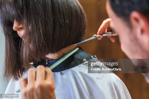 woman having her bob haircut styled by the hairdresser during her appointment - cut hair stock pictures, royalty-free photos & images