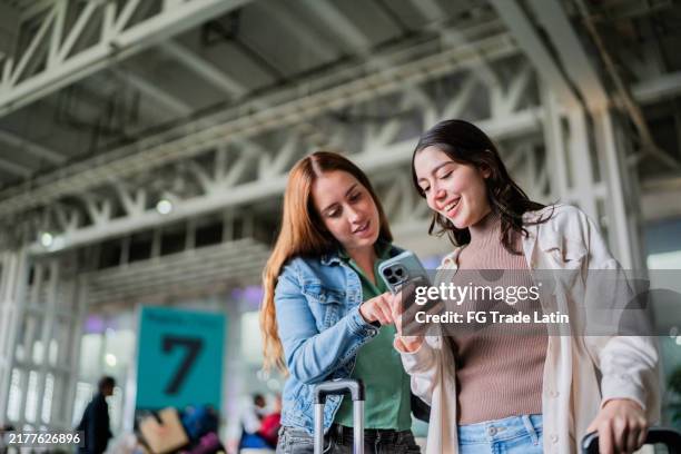 amici, donne, che parlano e usano, telefono cellulare, all'aeroporto - taxi foto e immagini stock