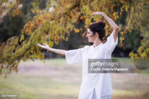 donna che esercita il qi gong - sistema immunitario foto e immagini stock