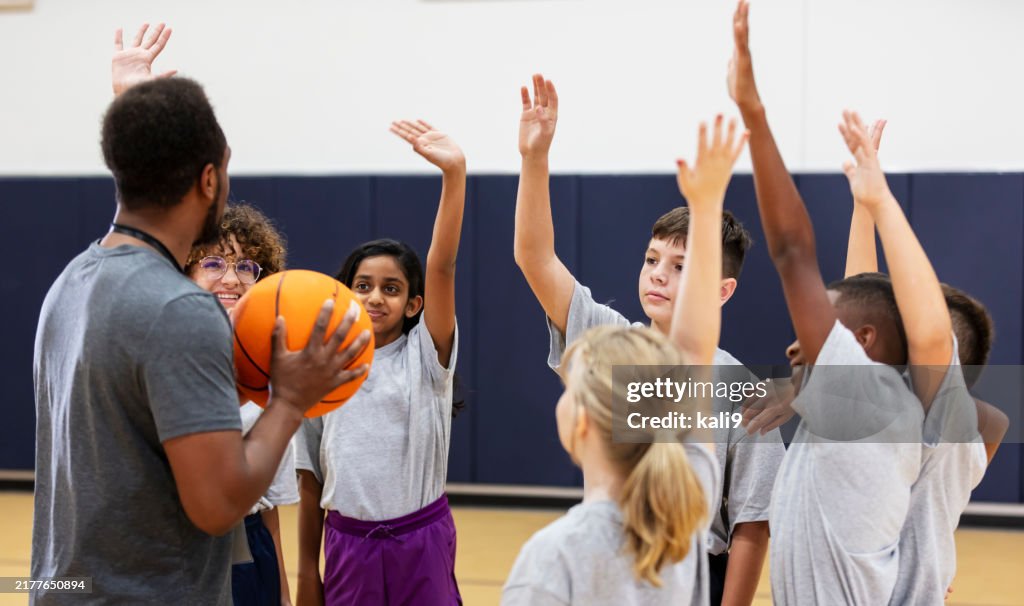 Elementary students in school gym playing basketball
