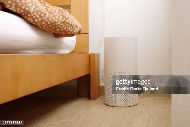 air purifier next to a wooden bed - air purifier stock pictures, royalty-free photos & images