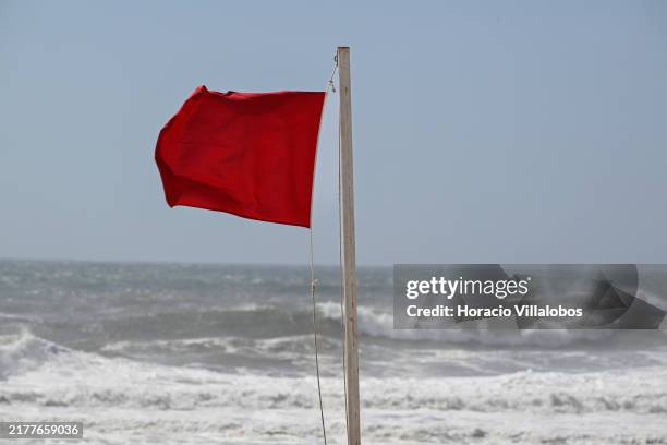 Red flag signals dangerous waters for bathing while large waves brake in Carcavelos beach after the passage of storm Kirk on October 09 in Cascais,...
