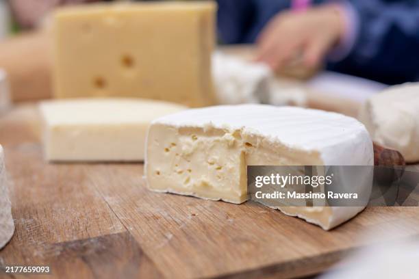 portioning cheese on a wooden cutting board - emmenthal stock pictures, royalty-free photos & images