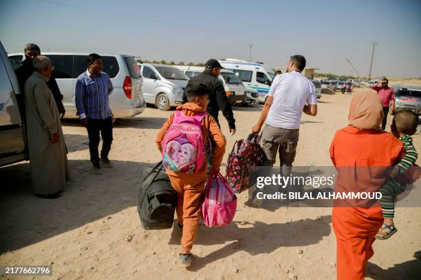 Syrians who were refugees in Lebanon return to their home country after a journey to the opposition held northern Idlib province through the crossing...