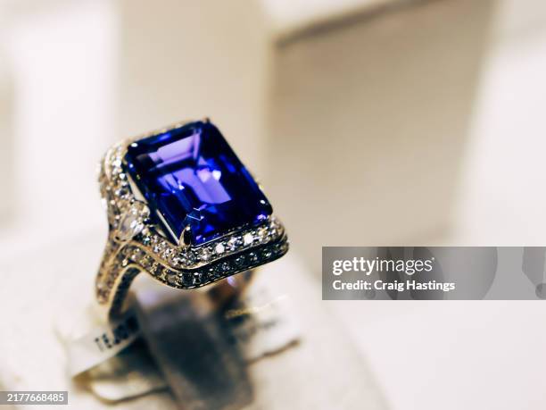 dubai souk - macro close up sapphire & topaz coloured gemstone set rings arranged in a row in jewellery store shop setting. luxury ring display with shining colourful stones and diamonds. high end luxury shopping - zaffiro foto e immagini stock