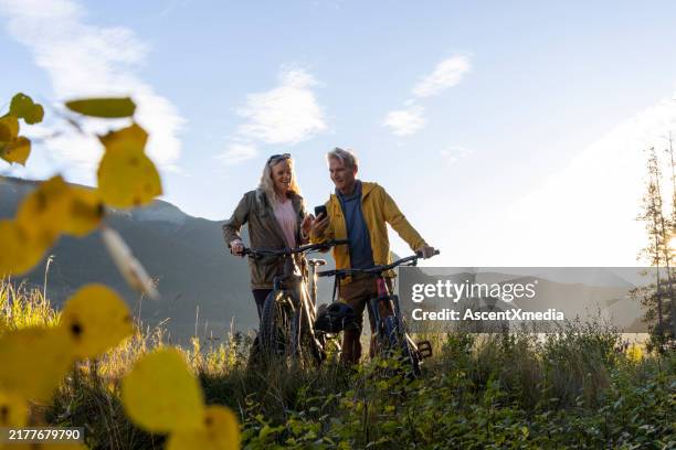mature couple with bicycles in autumn - canadian rockies stock pictures, royalty-free photos & images