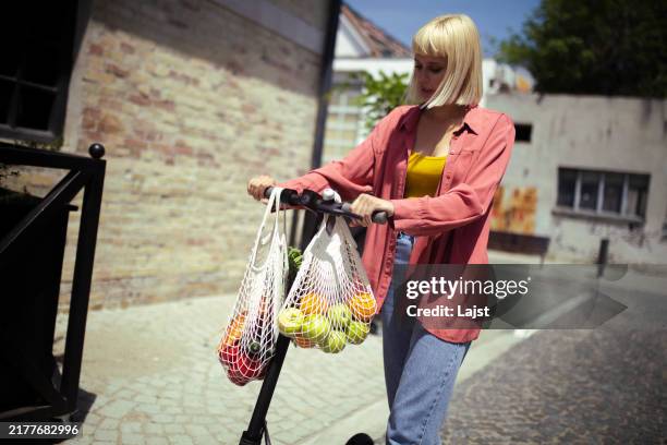 después de comprar frutas y verduras en el supermercado, la femal - bolsa reutilizable fotografías e imágenes de stock