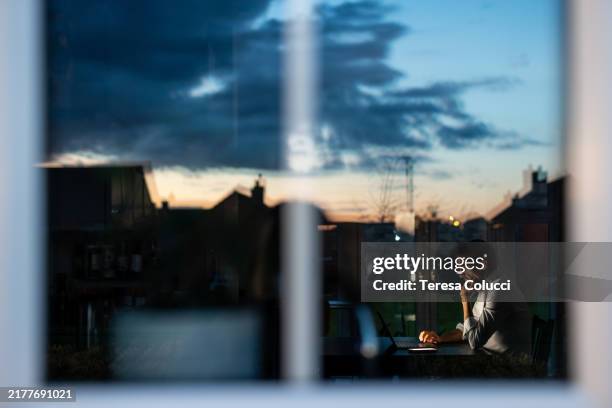 homme d’affaires travaillant à domicile tard le soir à l’aide d’un ordinateur portable - crépuscule photos et images de collection