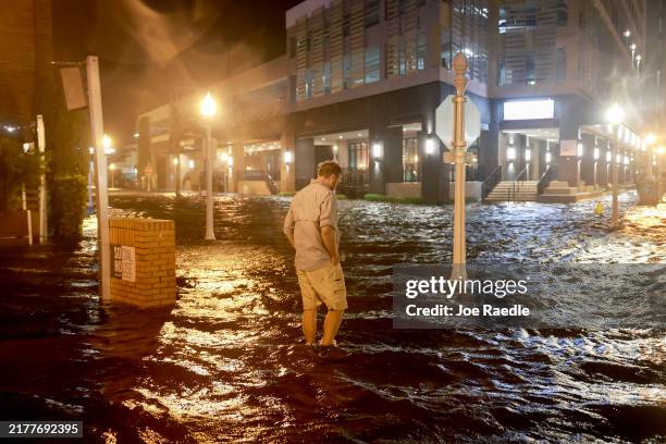 Brandon Marlow walks through surge waters flooding the street after Hurricane Milton came ashore in the Sarasota area on October 09 in Fort Myers,...