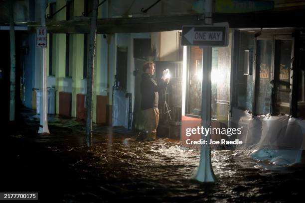 Person walks through surge waters after Hurricane Milton made landfall in the Sarasota area on October 09 in Fort Myers, Florida. Milton, coming on...