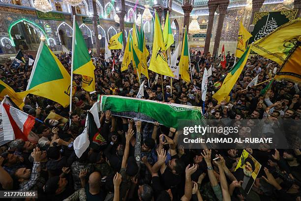 People carry the coffin of Iran's Islamic Revolutionary Guards Corps commander Abbas Nilforoushan during his funeral procession near the Imam Hussein...