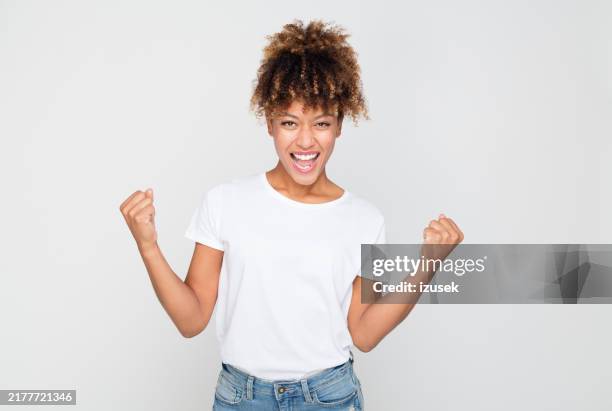 excited afro amercian woman celebrating success - simple fist stock pictures, royalty-free photos & images