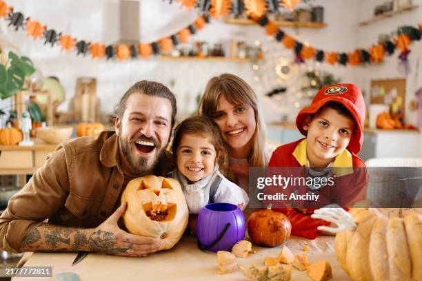retrato de una familia feliz y sonriente haciendo decoraciones de halloween - ayote fotografías e imágenes de stock