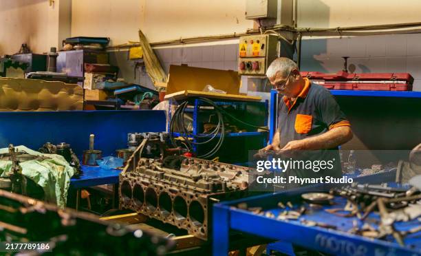 auto mechanic working on a large engine in a garage. repair service. - dismantling stock pictures, royalty-free photos & images