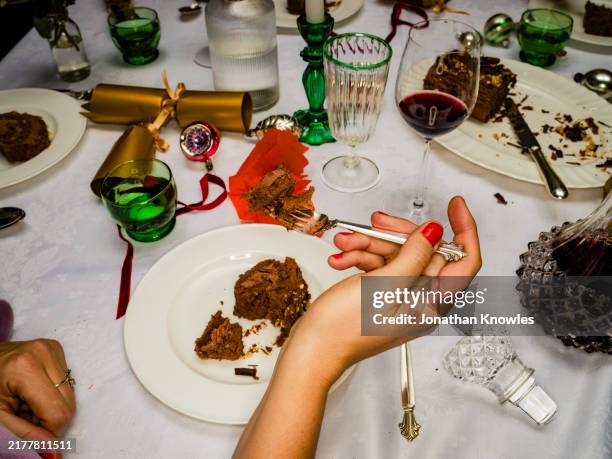 close up over the shoulder view woman eating chocolate christmas dessert - dessert foto e immagini stock