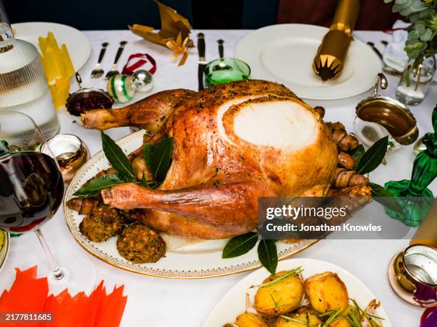 close up traditional roasted turkey on christmas dinner table - plate stock pictures, royalty-free photos & images