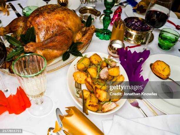 high angle view roasted christmas turkey and potatoes on dining table - roast potato stock pictures, royalty-free photos & images