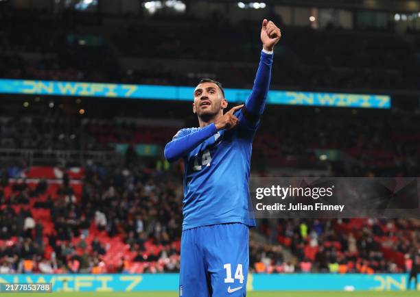 Vangelis Pavlidis of Greece celebrates scoring his team's second goal as he gestures towards his black armband in honour of the passing of former...