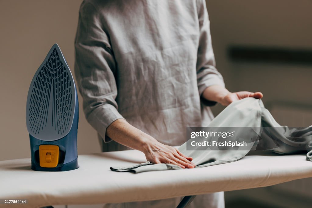 Persona planchando ropa con moderna plancha de vapor a bordo