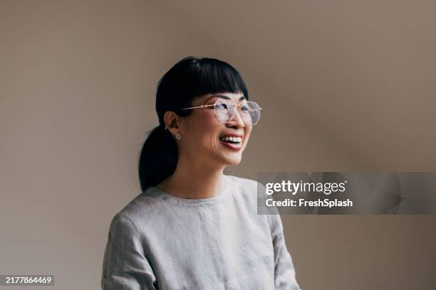 mulher sorridente usando óculos em ambiente casual - etnia oriental - fotografias e filmes do acervo