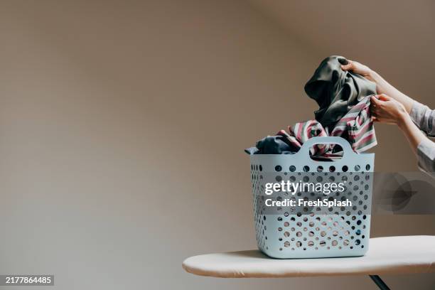 hände organisieren wäschestapel in einem blauen korb - weidenkätzchen stock-fotos und bilder