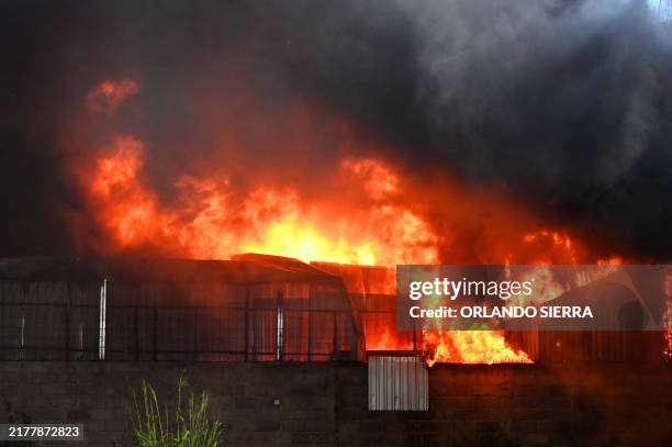 View of fire engulfing the spare parts warehouses of the century-old Corporacion Flores, dedicated to the import and distribution of Japanese...