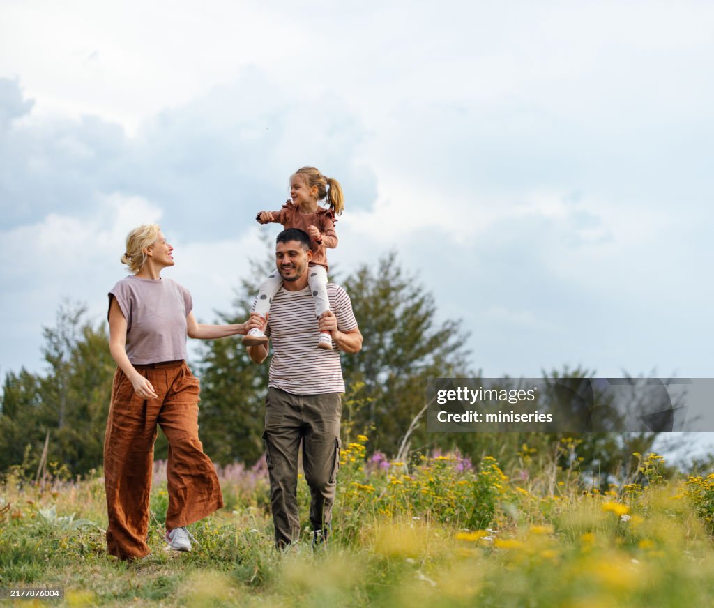Glückliche Familie genießt einen Spaziergang in der Natur auf dem Land