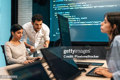Software developers checking programming code on computer screen. Software developers checking programming code on computer screen.