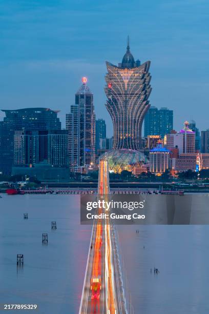 car trail on bridge with macau city skyline in the background - macao fotografías e imágenes de stock
