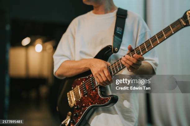 asian chinese guitarist practicing guitar at backstage rehearsal before music concert - pop music stock pictures, royalty-free photos & images