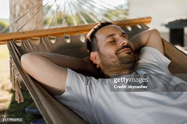 hombre relajado tomando una siesta en hamaca. - hamaca fotografías e imágenes de stock