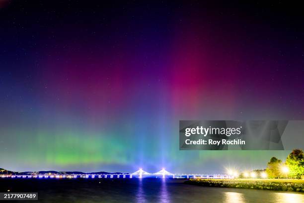 The Northern Lights or Aurora Borealis are visible over the Tappan Zee or Governor Mario M. Cuomo Bridge Bridge on October 11, 2024 near New York...
