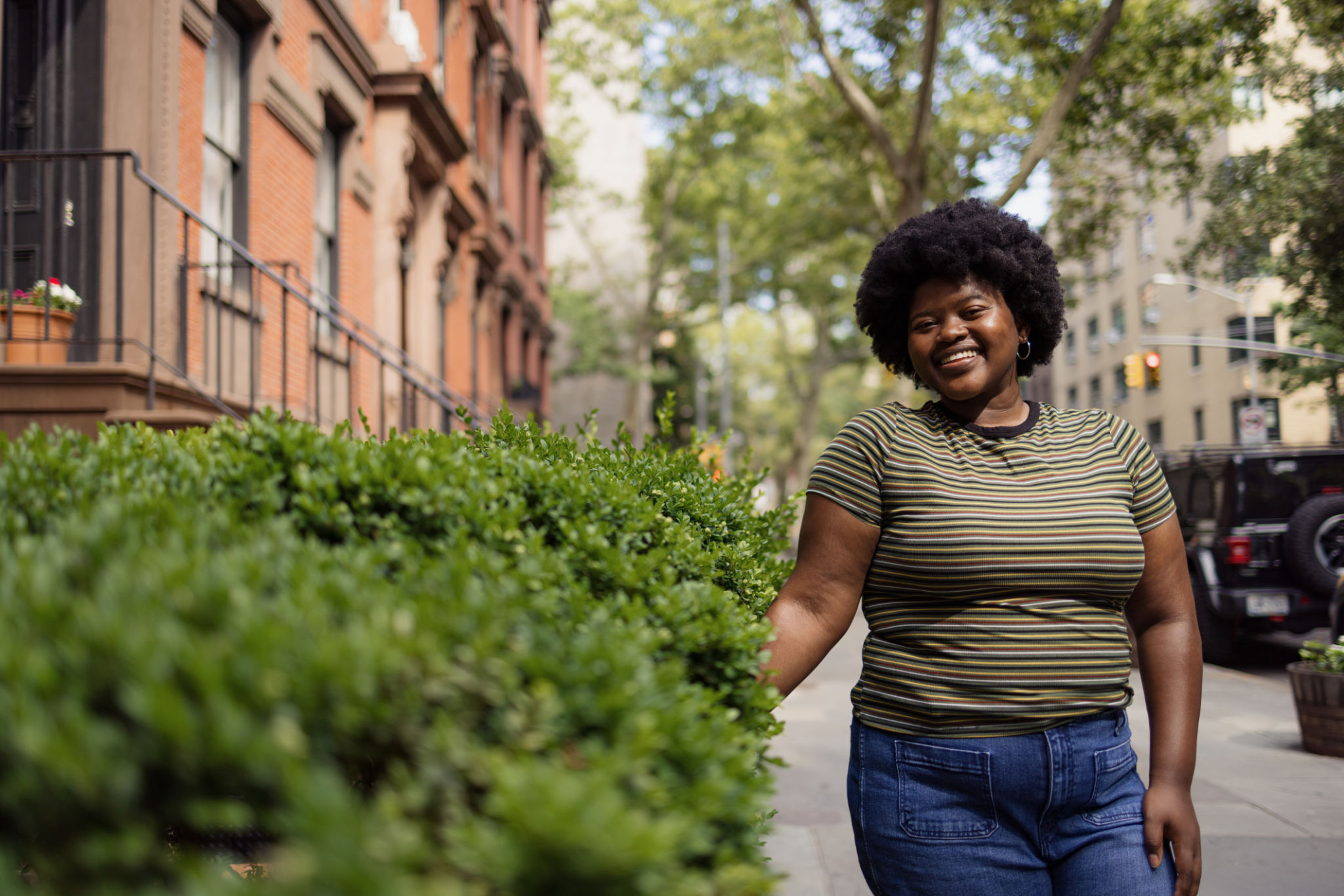 Happy black woman with Afro hair by the bush on the street. Happy black woman with Afro hair by the bush on the street.