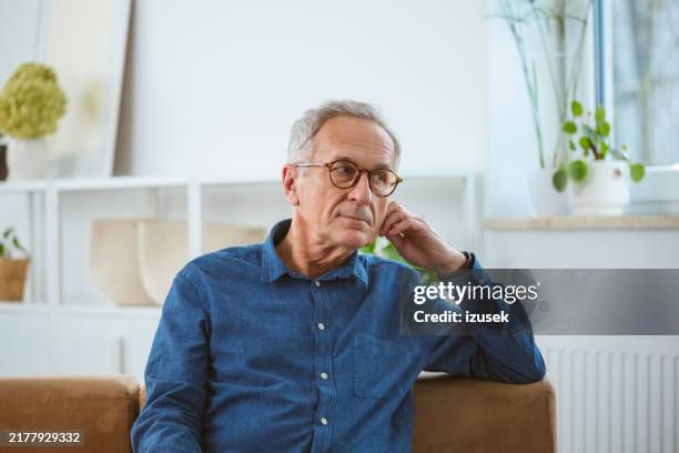 thoughtful senior man at home - navy shirt stock pictures, royalty-free photos & images