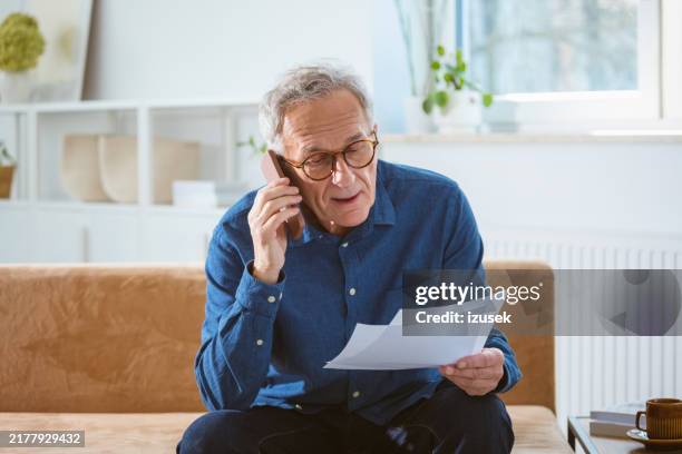 worried senior man talking on phone - verward stockfoto's en -beelden