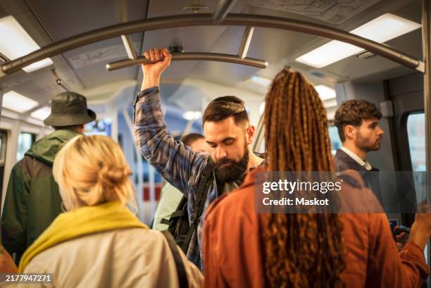 commuters standing in illuminated train - hamburg train stock pictures, royalty-free photos & images