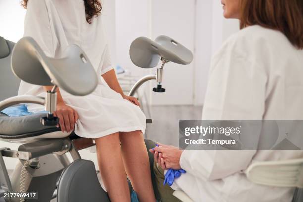 after completing the gynecological examination, the doctor and patient converse. - gynaecologist stock pictures, royalty-free photos & images