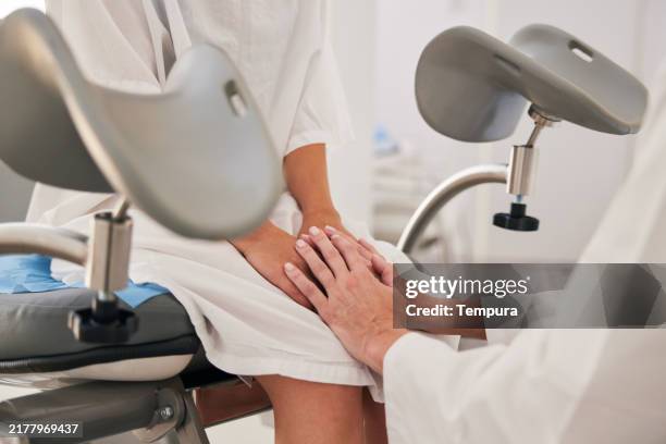following the gynecological exam, the obstetrician takes the patient's hands reassuringly. - gynaecoloog stockfoto's en -beelden