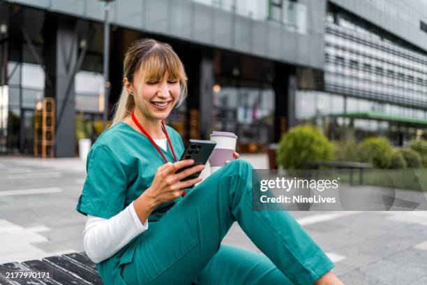 female nurse using a mobile phone during coffee break - white woman calling 911 stock pictures, royalty-free photos & images