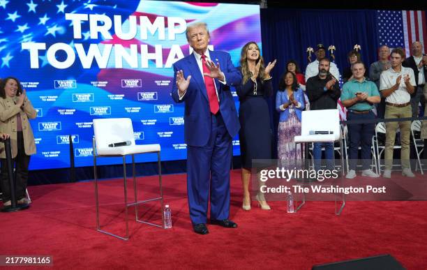 October 14 : Republican presidential nominee former President Donald Trump dances on stage with South Dakota Gov. Kristi Noem, during a town hall...